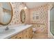 Bathroom with double vanity, floral wallpaper and checkered flooring at 422 Roselawn Pl, Charlotte, NC 28211