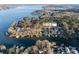 An aerial view of lakefront homes and docks on a wooded shoreline with calm blue water at 680 Lake Head Rd, Norwood, NC 28128