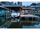 Well-lit boat dock with room for multiple boats and an adjacent entertainment area with dining at 680 Lake Head Rd, Norwood, NC 28128