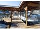 Covered boat dock with ample space for watercraft and relaxing by the lake with a table and chairs at 680 Lake Head Rd, Norwood, NC 28128