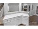 White kitchen with L-shaped island and ample counter space at 8249 Chatham Oaks Dr, Concord, NC 28027