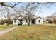 Charming exterior of white brick home with black trim and manicured lawn at 912 Hickory Grove Rd, Gastonia, NC 28056