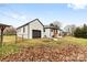 Exterior rear view of white brick home with black trim and detached garage at 912 Hickory Grove Rd, Gastonia, NC 28056