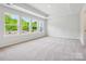 Expansive bedroom with a tray ceiling and multiple large windows offering views of the surrounding trees at 10121 Mamillion Dr, Huntersville, NC 28078