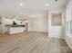 Open-concept living room with modern light fixtures and flows into a stylish kitchen with white cabinetry at 10121 Mamillion Dr, Huntersville, NC 28078