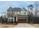 Two-story home with brick and gray siding and a two car garage and landscaping at 1124 Greenbridge Dr, Matthews, NC 28105