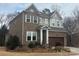 Two-story home with brick and gray siding with well-manicured landscaping and a two car garage at 1124 Greenbridge Dr, Matthews, NC 28105