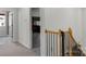 Hallway view showcasing wooden staircase, neutral carpet, and an open doorway to the next room at 1124 Greenbridge Dr, Matthews, NC 28105