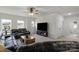 Bright living room with plush leather sofas, modern ceiling fan, and large windows at 1124 Greenbridge Dr, Matthews, NC 28105