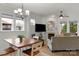 Bright living room with fireplace, large windows, hardwood floors, and a dining area at 1124 Greenbridge Dr, Matthews, NC 28105