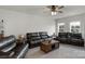 Spacious living room featuring leather sofas, a ceiling fan, and large windows for ample natural light at 1124 Greenbridge Dr, Matthews, NC 28105