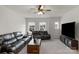 Comfortable living room with modern ceiling fan, plush sofas, and bright natural light from the large windows at 1124 Greenbridge Dr, Matthews, NC 28105