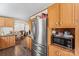 Kitchen featuring a stainless steel refrigerator, wood cabinets, and open dining area at 1149 Rollingbrook Ct, Kings Mountain, NC 28086