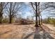 A single-story brick home sits on a spacious lot with mature trees, offering a serene setting at 13501 Mullis Rd, Midland, NC 28107