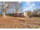 Cozy one-story home featuring a brick chimney and vinyl siding, set on a large lot with mature trees at 13501 Mullis Rd, Midland, NC 28107