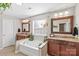 Bathroom features double vanity, soaking tub, and large mirror at 138 Byers Commons Dr, Mooresville, NC 28117