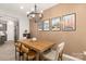 Dining room featuring a wooden table with seating, modern chandelier, and stylish wall decor in a warm color palette at 14041 Whistling Teal Dr, Charlotte, NC 28262