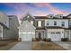 Charming two-story townhome with attached garage, landscaped front yard, and modern architectural details at 14041 Whistling Teal Dr, Charlotte, NC 28262