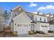 Inviting two-story townhome featuring an attached garage, manicured yard, and Craftsman-style accents at 14041 Whistling Teal Dr, Charlotte, NC 28262