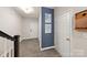 Hallway with white doors, wooden floors, and a bold blue accent wall with modern city artwork at 14041 Whistling Teal Dr, Charlotte, NC 28262