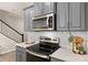 Modern kitchen detail features stainless steel appliances, white countertops, subway tile backsplash, and gray cabinets at 14041 Whistling Teal Dr, Charlotte, NC 28262