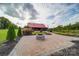 Brick patio with fire pit, landscaping, and barn in background at 15554 Highway 601 S Hwy, Midland, NC 28107