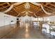 Large event space with exposed beams, string lights, and tables for a wedding reception at 15554 Highway 601 S Hwy, Midland, NC 28107