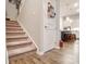 Carpeted staircase with wooden railings and kitchen view at 267 Portrait Way, Indian Trail, NC 28079