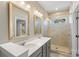 Bathroom featuring double sinks, framed mirrors, and glass shower with beige tiling at 2848 Grand Union Way, Charlotte, NC 28209