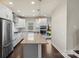 A modern kitchen featuring white cabinets, stainless steel appliances, and a large island with stone countertops and dark wood floors at 2848 Grand Union Way, Charlotte, NC 28209