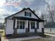 New construction home with white siding, black accents, and a brick base at 401 Fourth St, Stanley, NC 28164