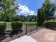 Brick patio with black metal fence overlooking a tranquil pond and lush greenery at 4723 Polo Gate Blvd, Charlotte, NC 28216