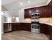 Kitchen with stainless steel appliances, dark wood cabinets, and light countertops at 4723 Polo Gate Blvd, Charlotte, NC 28216