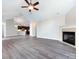 Open living room with hardwood floors, kitchen view, and fireplace at 4723 Polo Gate Blvd, Charlotte, NC 28216