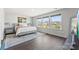 A bright bedroom featuring hardwood floors, a queen bed, and a row of sunlit windows at 5034 Moselle Ave, Fort Mill, SC 29707