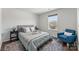 Cozy bedroom with a large window, comfortable bed, and an inviting blue armchair at 5034 Moselle Ave, Fort Mill, SC 29707