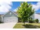 A well-maintained two-story home with a two-car garage, beautiful landscaping, and a healthy green tree in the front yard at 5034 Moselle Ave, Fort Mill, SC 29707