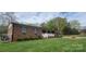 Beautiful brick home with blue shutters, covered porch, and lush green lawn at 5527 Dallas High Shoals Hwy Hwy, Dallas, NC 28034