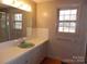 Neutral bathroom featuring a single sink vanity, window, and shower at 5590 S Nc 16 Business Hwy, Maiden, NC 28650