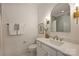 Well lit bathroom with a white vanity, gold hardware, and large arch mirror reflecting the shower at 625 Colorado Ave # B, Charlotte, NC 28206