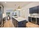 Bright kitchen with navy cabinets, a quartz island with seating, and a view into the adjacent living area at 625 Colorado Ave # B, Charlotte, NC 28206