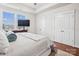 Bright bedroom with wood floors, modern TV, white trim and natural light coming in through the windows at 746 Waterscape Ct, Rock Hill, SC 29730