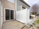 View of a backyard with a white fence, sliding glass door, and patio with space for outdoor seating at 8272 Golf Ridge Dr, Charlotte, NC 28277