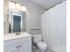 Bathroom features a white vanity, toilet, and a shower with a white curtain at 8272 Golf Ridge Dr, Charlotte, NC 28277