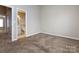 View of the bedroom, showcasing a carpeted floor and an open doorway to the bathroom at 8272 Golf Ridge Dr, Charlotte, NC 28277