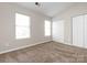 Bright bedroom featuring two windows and a closet, offering a comfortable and functional space at 8272 Golf Ridge Dr, Charlotte, NC 28277