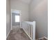 Hallway with neutral colored carpet leads to carpeted room with a window at 8272 Golf Ridge Dr, Charlotte, NC 28277