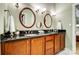 Stylish bathroom with double sinks, dark countertops, and wood-finished cabinets at 8405 Olde Troon Dr # 4A, Charlotte, NC 28277