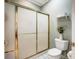 Clean bathroom featuring a glass-door shower, toilet, and a small decorative shelf at 8405 Olde Troon Dr # 4A, Charlotte, NC 28277