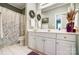 Bright bathroom with a long white vanity, framed mirror, and a shower and tub combo at 8405 Olde Troon Dr # 4A, Charlotte, NC 28277